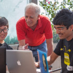 Geoff Kuenning consults with two students during a class