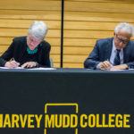 Man and woman sit at table signing documents