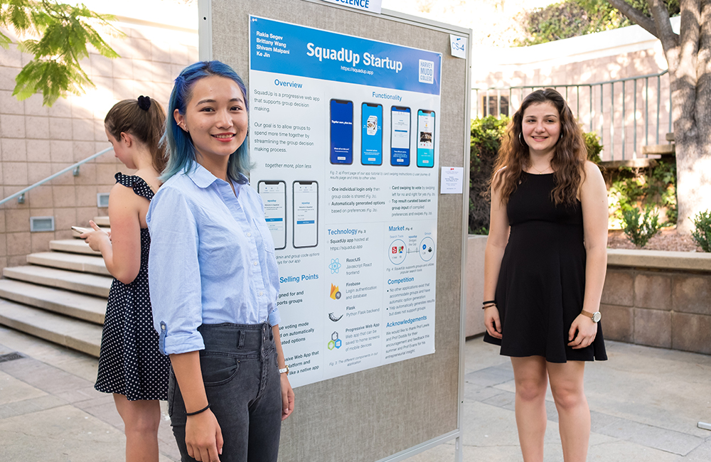 Students stand in front of research poster