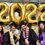 grads in front of 2022 balloon