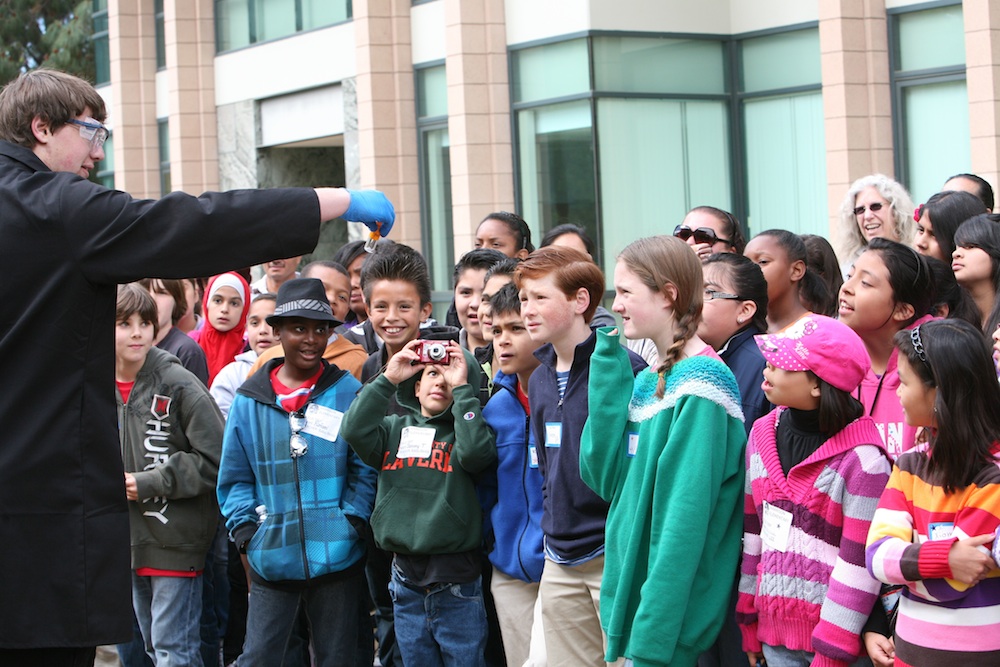 Student demonstrates to young students.