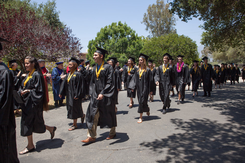 grads in caps and gowns walking