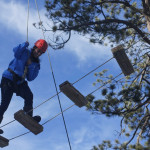 Student crossing rope bridge.