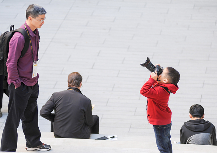 Young boy takes photo of parent at Harvey Mudd event