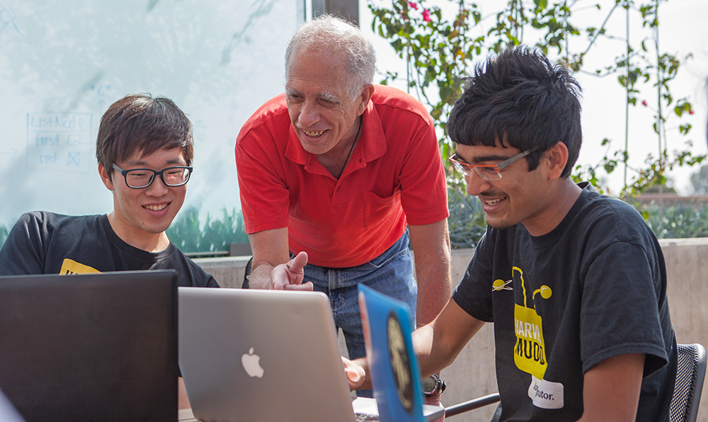 Geoff Kuenning consults with two students during a class