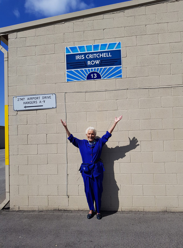 Iris Critchell in front of the hangar row that has been named for her