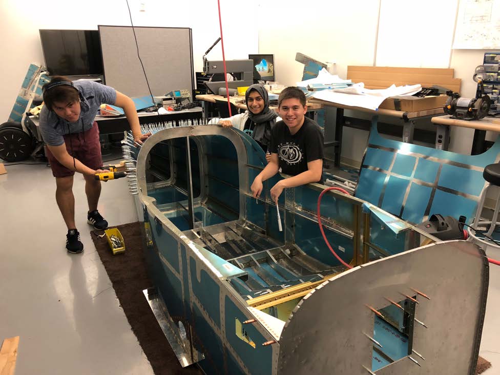 Students working on the body of an airplane