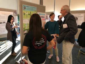 Harvey Mudd faculty discuss a poster of a student volunteer