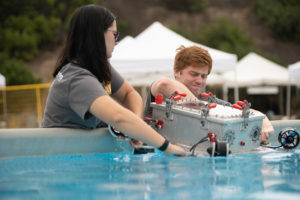 students putting AUV into water