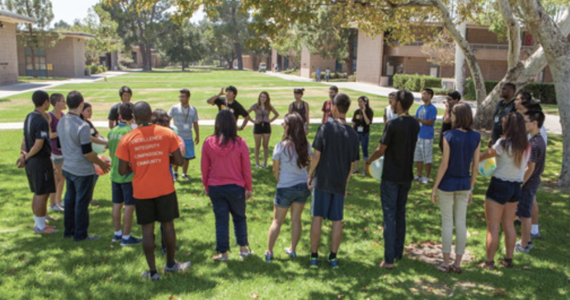 Summer Institute students form a circle outside on campus