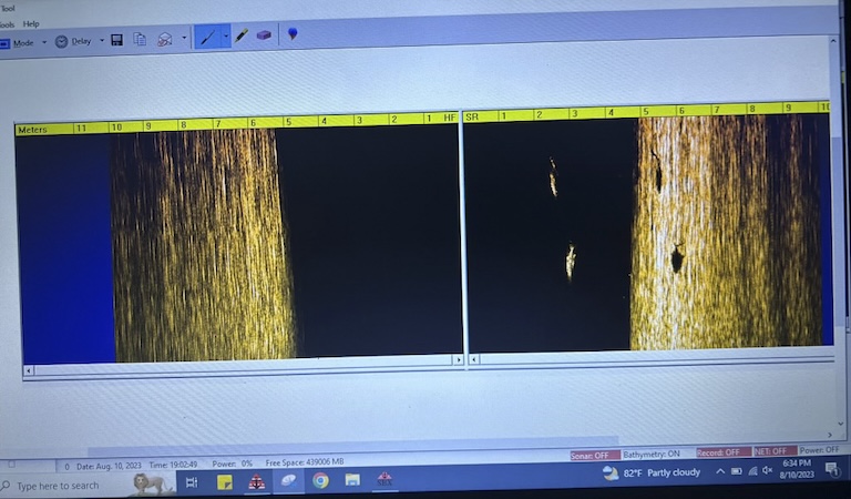 On a computer screen, two images appear side by side. They are infrared images of the bays seafloor. 