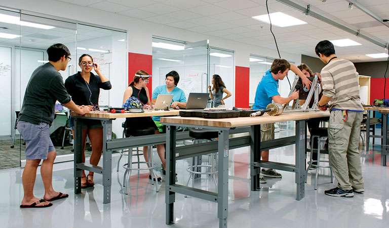 Brightly lit workspace with people working at benches