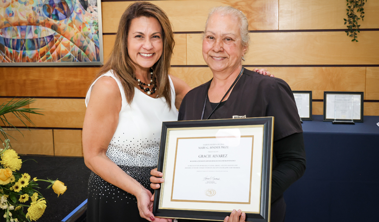 Dana Nagengast, assistant vice president/chief human resources officer presents award to Gracie Alvarez, building attendant