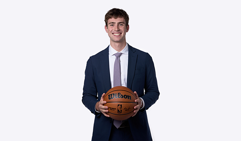 Jonah Heimann wearing a suit and holding a basketball