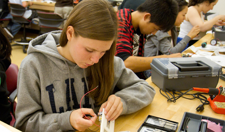 Students works on electronic project at workbench