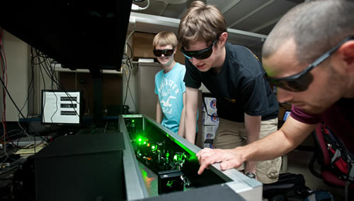 Students work on laser equipment.