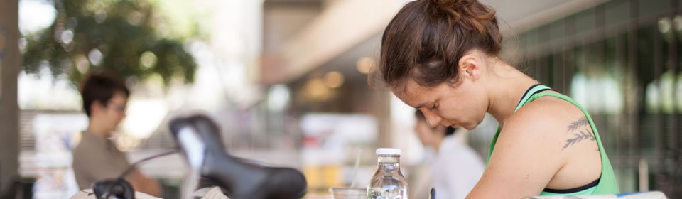 Female student writes at table