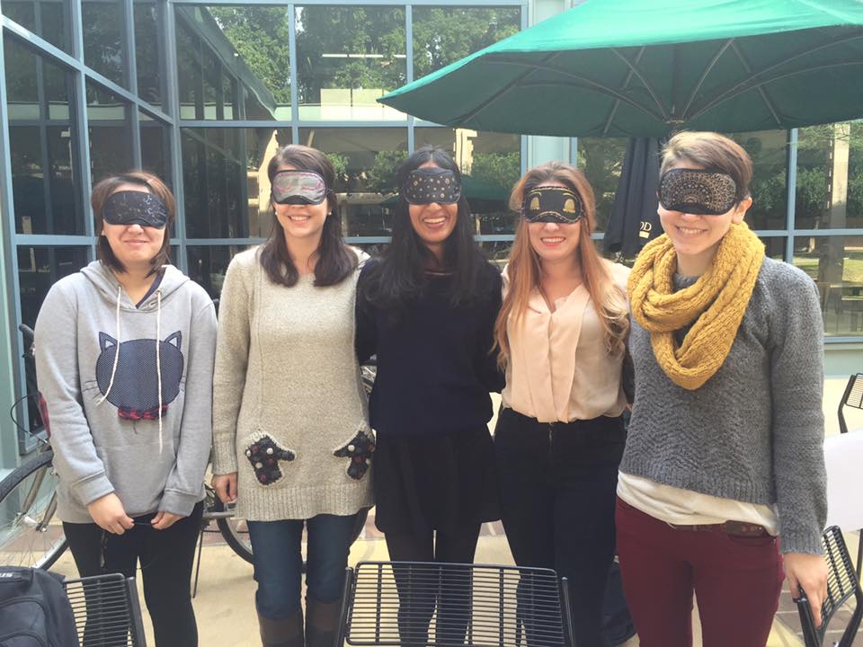 Wellness Peers and Michelle Harrison, Wellness Coordinator, pose with personalized sleep masks at their event outside of the Hoch.