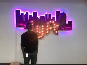 Kofi poses in front of the Lyft sign at their headquarters in San Francisco