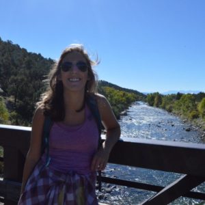 Moira standing on a bridge over a river