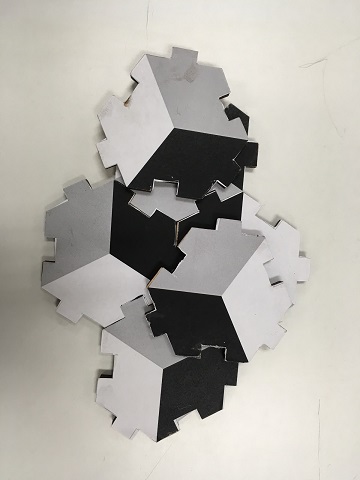 Black, white, and gray Hexmound pieces, with notched edges that interlock.