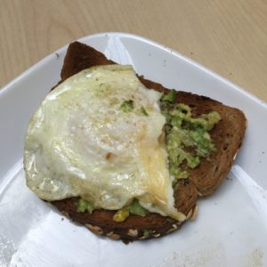 toasted oat wheat bread with mashed avocado and a medium fried egg