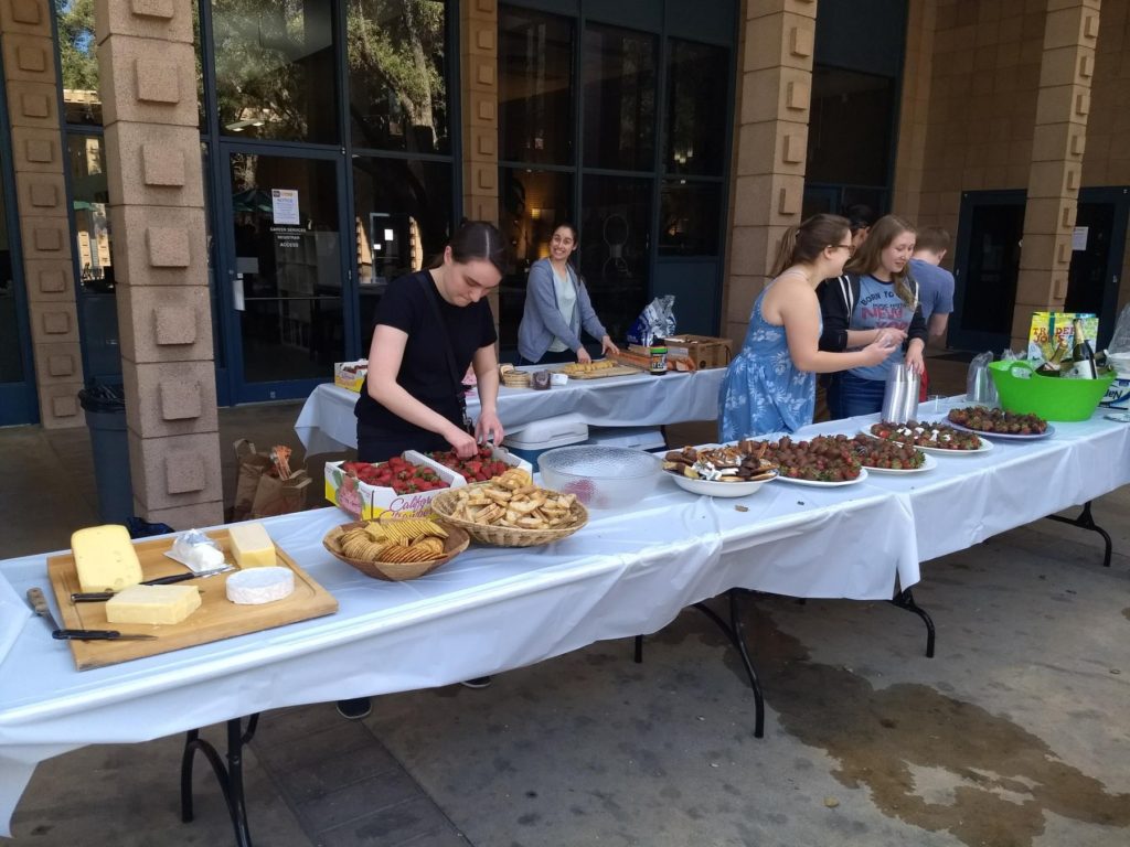 A table of food with writing center consultants setting up.