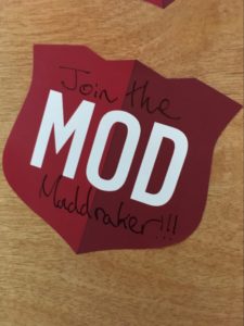 A red sticker with white text spelling out “MOD”. Around that are the words “Join the Muddraker!!!”