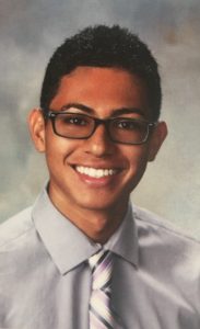 Headshot of Mason Acevedo wearing glasses, a gray collared shirt, and a striped tie.