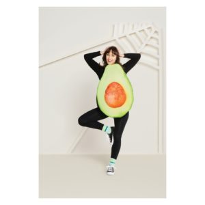 A woman poses in an avocado costume. Her torso has half an avocado on it. 