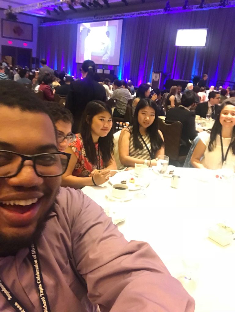 Izzy takes a selfie with 4 other conference attendees