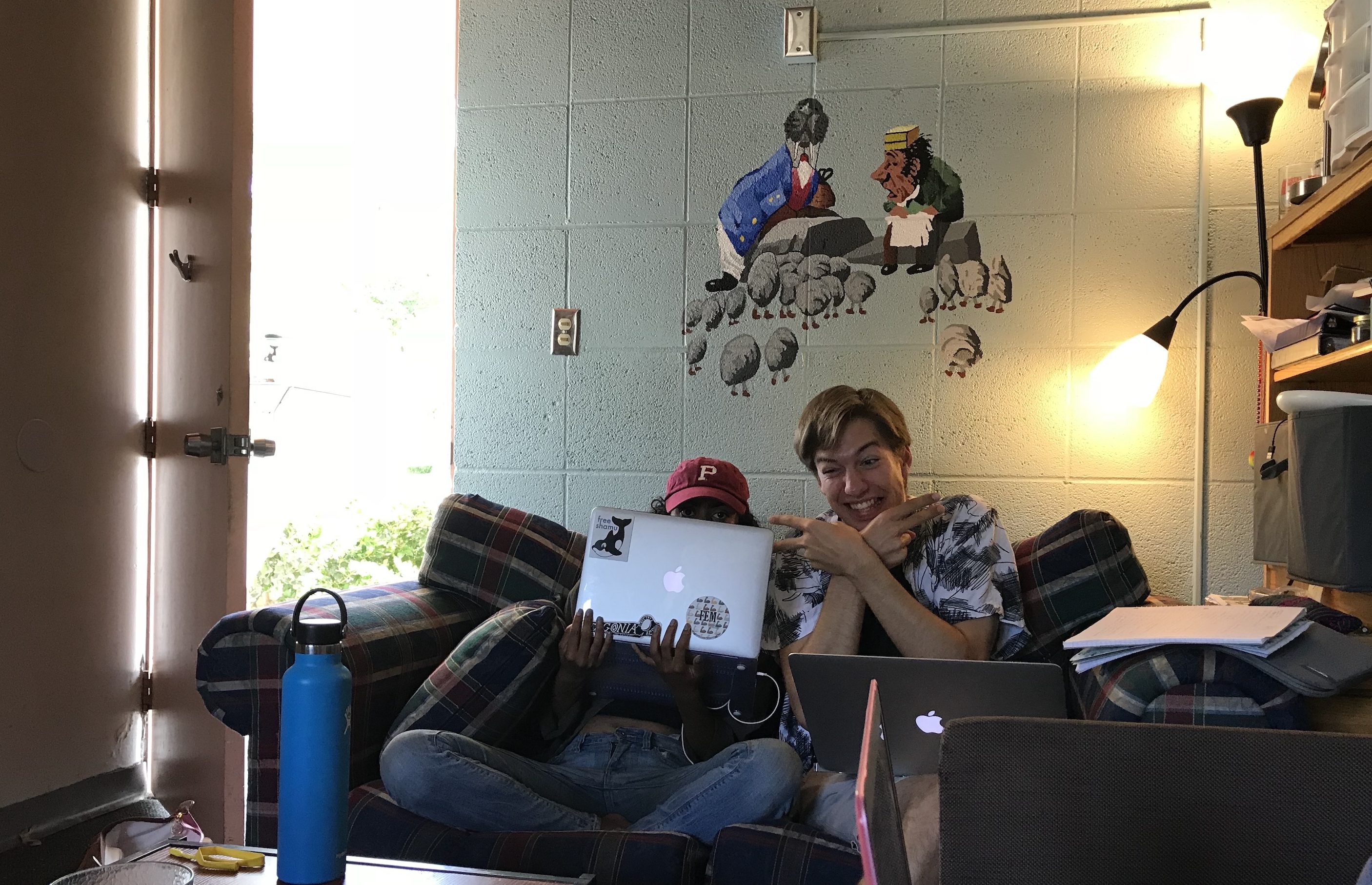 Friend Neeta hides behind her laptop while friend Tom makes a funny face