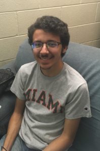 Medium shot of Kalani Dúran smiling, sitting on a couch.