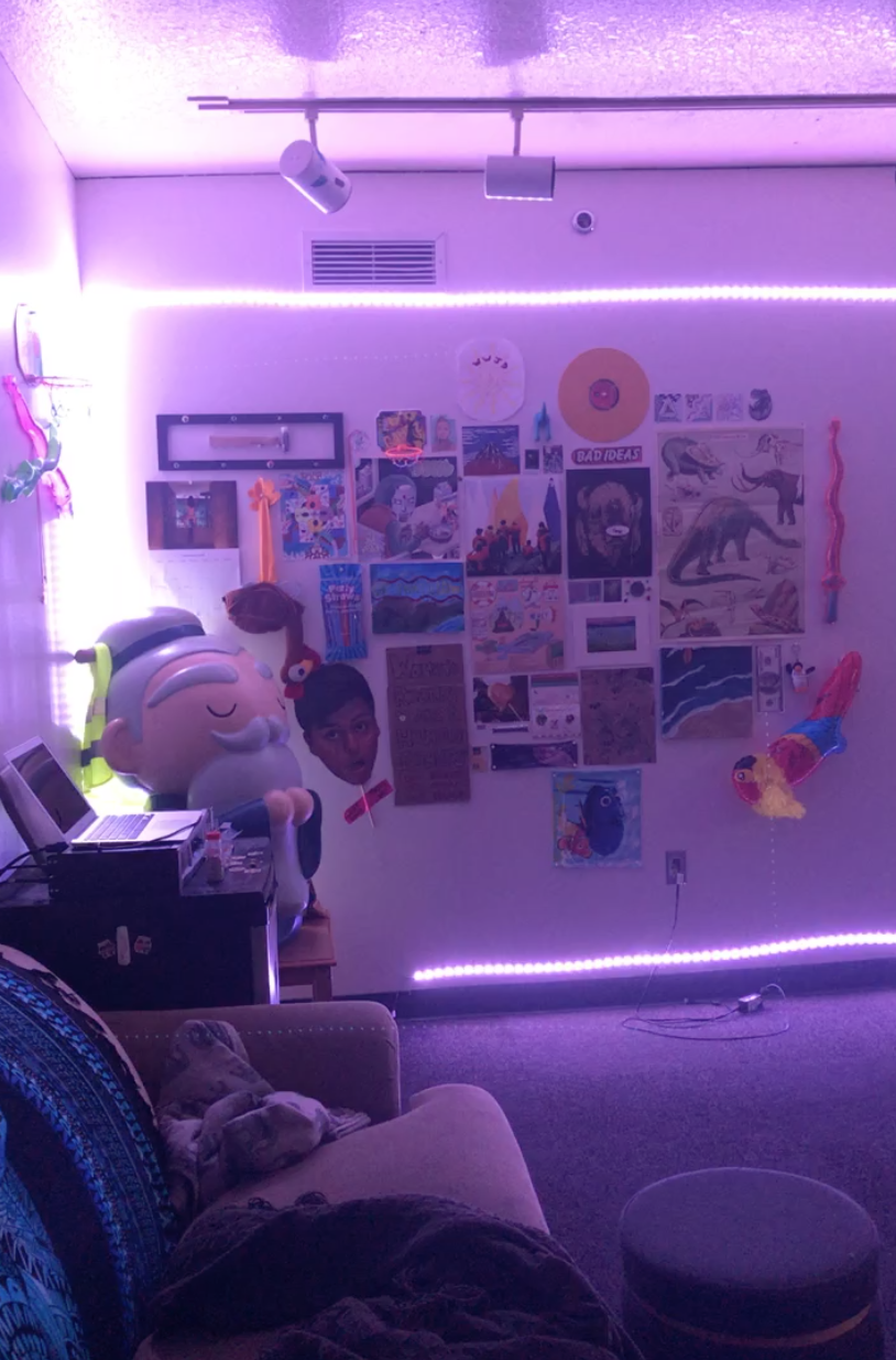 Lots of pictures and records on a wall surrounded by purple LEDs