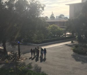 Photograph of 6 women following a tour guide across a college campus