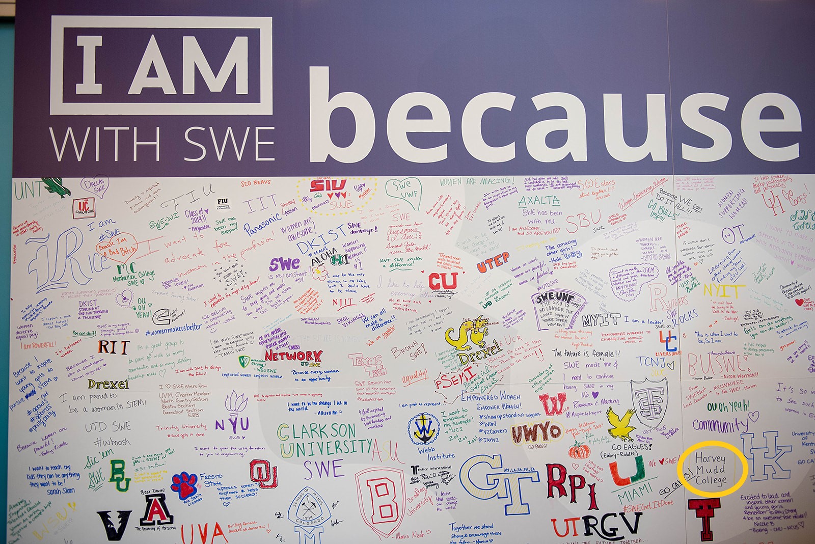 A board with a bunch of different colleges written under a large prompt "I am with SWE because"