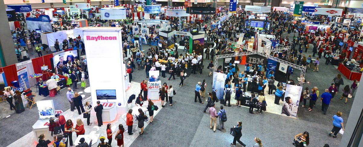 A photo of a large convention center with different booths for different companies recruiting students.