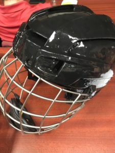 A shiny black hockey helmet