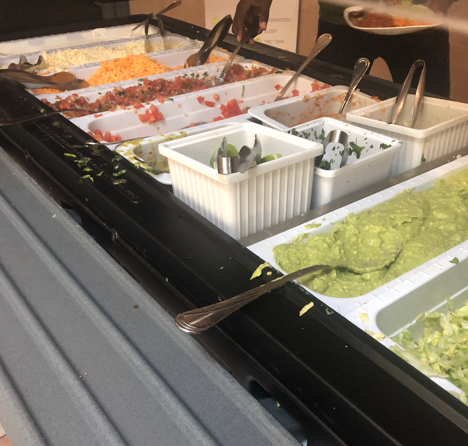 The fajita topping bar has guac, cheese, tomatoes, lettuce, cilantro, green onions, and pico de gallo