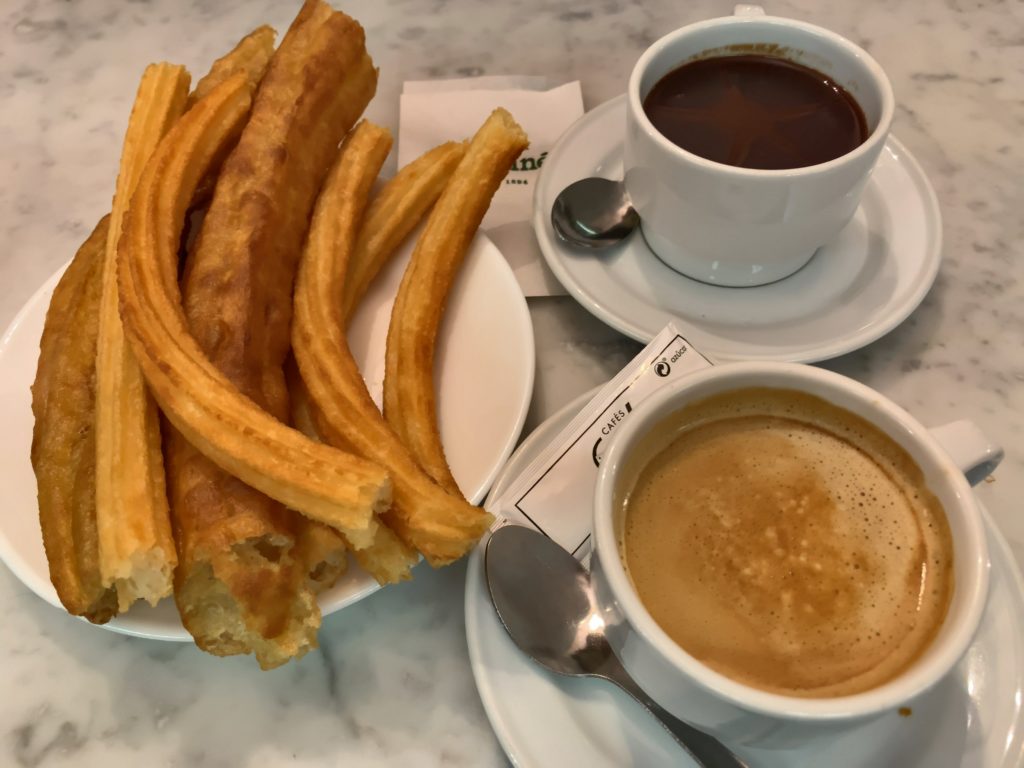 churros, a cup of hot chocolate, and a cup of coffee