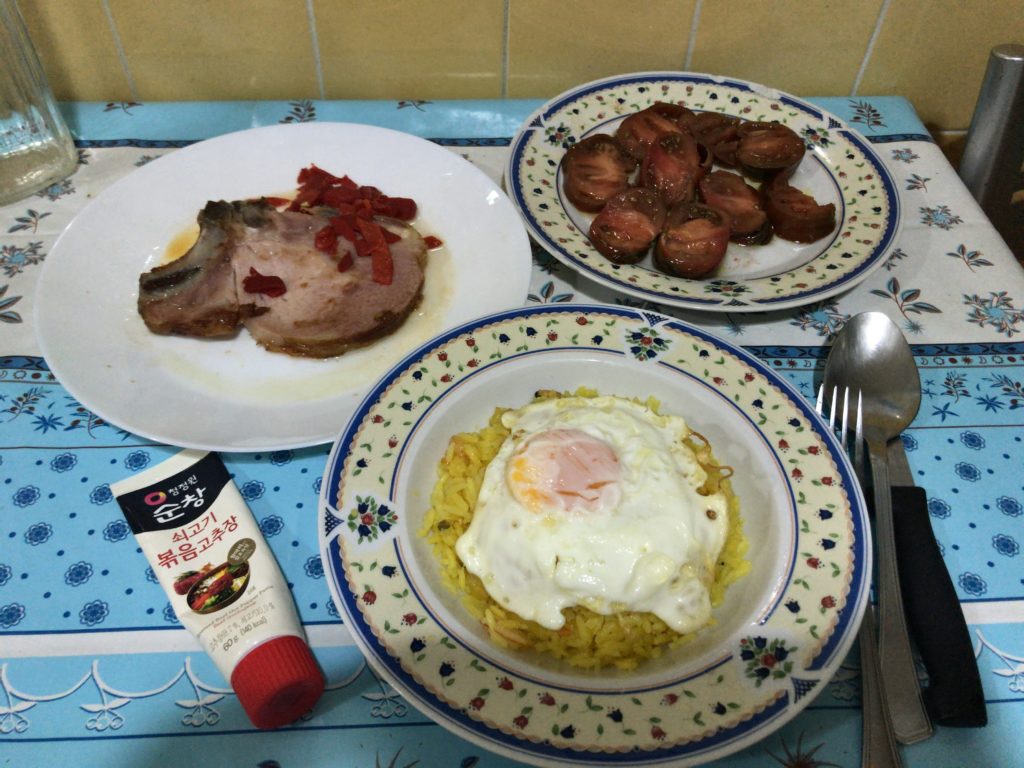 three dishes with food and utensils on a table