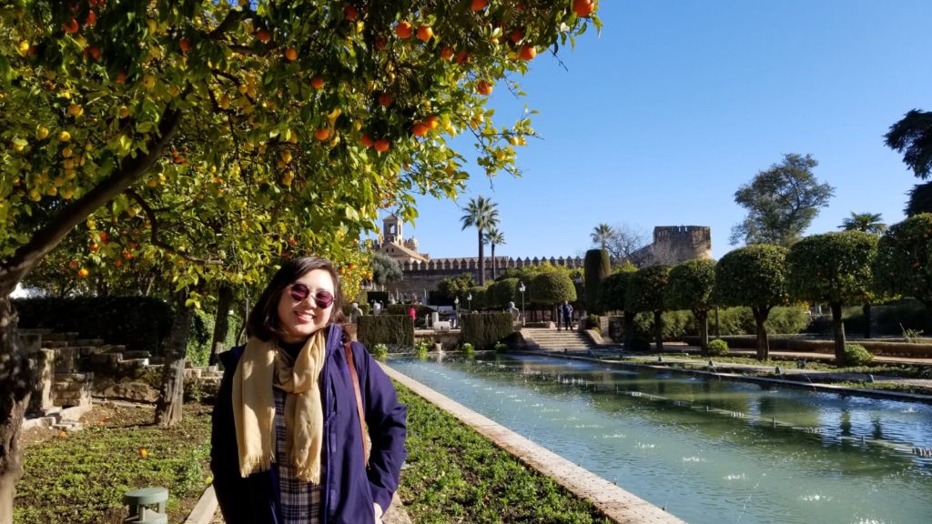 Jasmine in front of a garden with orange trees and a fountain
