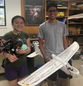 Mason Acevado and Kathryn Chan holding a drone and a glider.