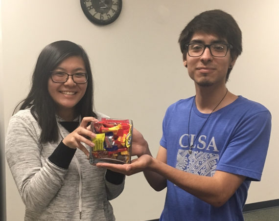 Jose Suarez and Emily Chin holding a bowl of candy 