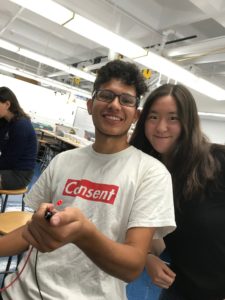 Mason and Crystal in E79 Practicum - Mason is holding a small LED that is being controlled by a computer. 