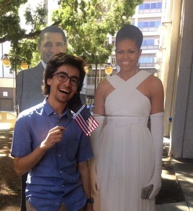 Joaquin posing with an American flag and a cardboard cutout of the Obamas