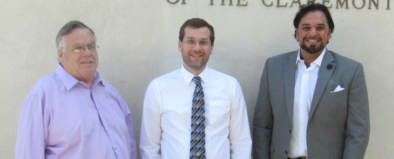 Three men in front of a white wall.