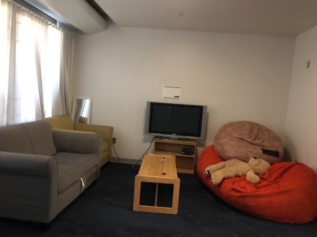 Living room area with couch, table, and TV.