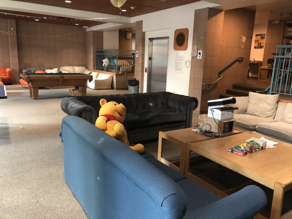 A collection of couches with a Winnie the Pooh stuffed animal and tables.