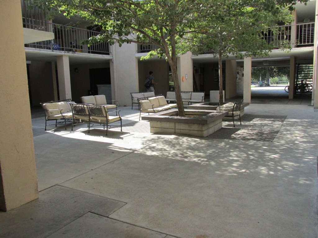 Image of courtyard with chairs and a central tree.